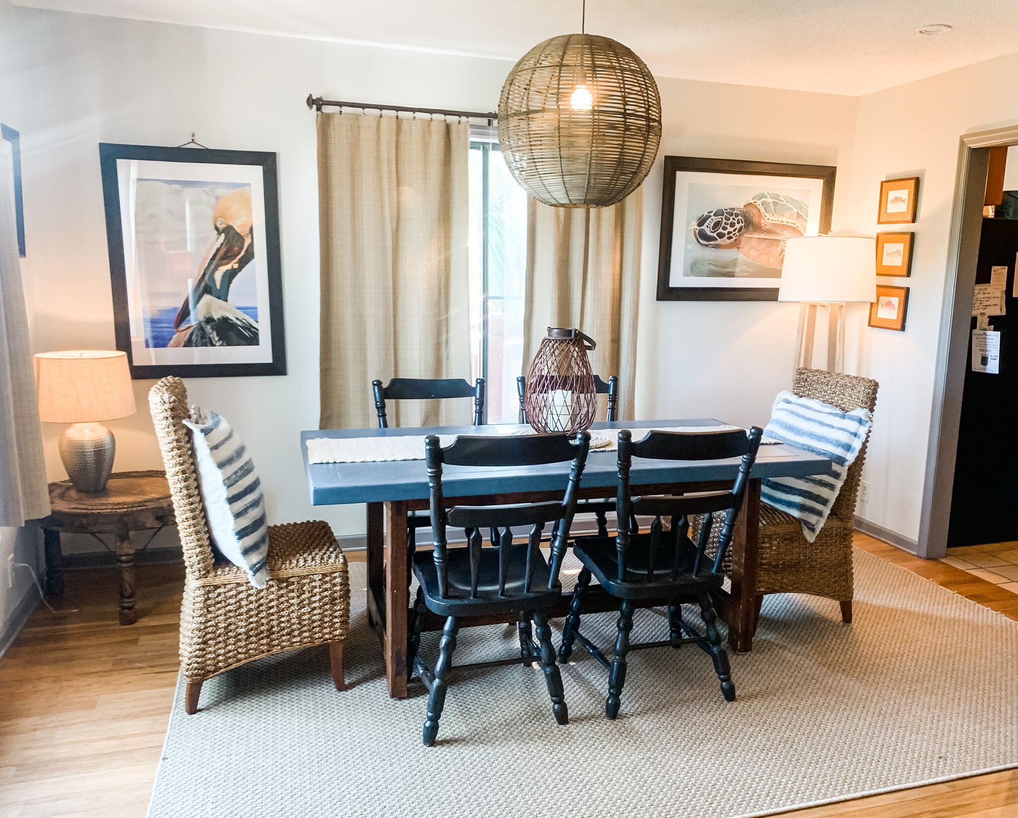 A dining area with a table, chairs, and a hanging light fixture.