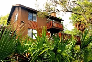 Escape to a serene tropical haven with a spacious balcony overlooking lush gardens and bright interior spaces.
