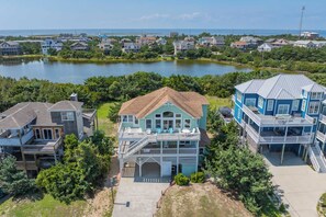 A coastal residential area with houses near a body of water, featuring balconies and a view of the sea.