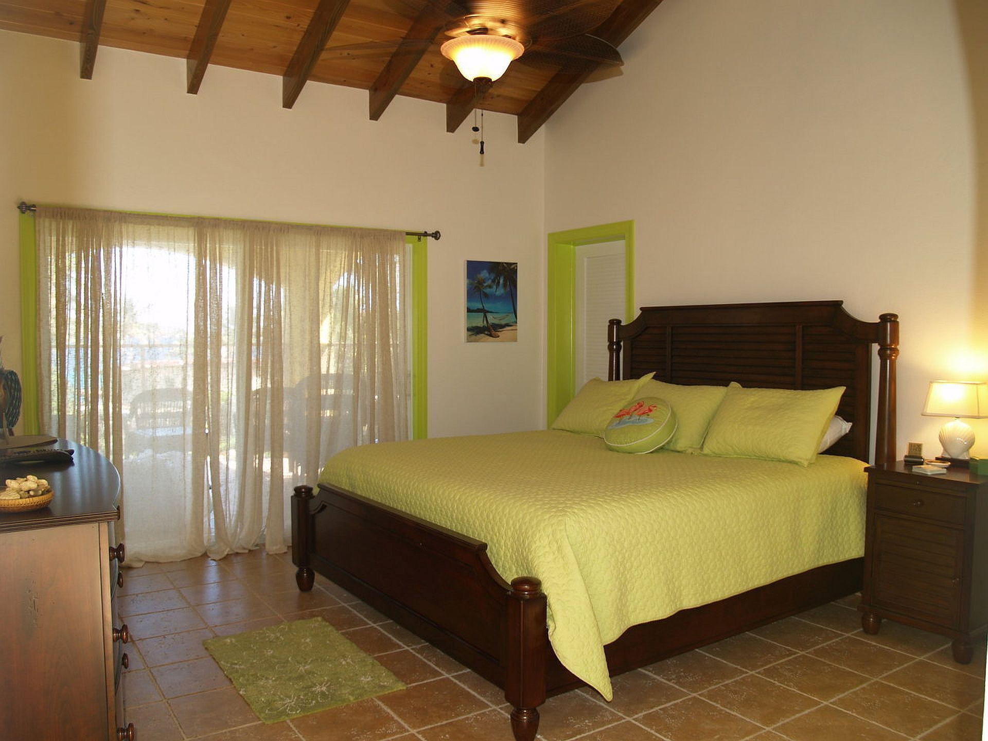 A bedroom with a wooden bed, green curtains, a wooden ceiling, and a tiled floor.