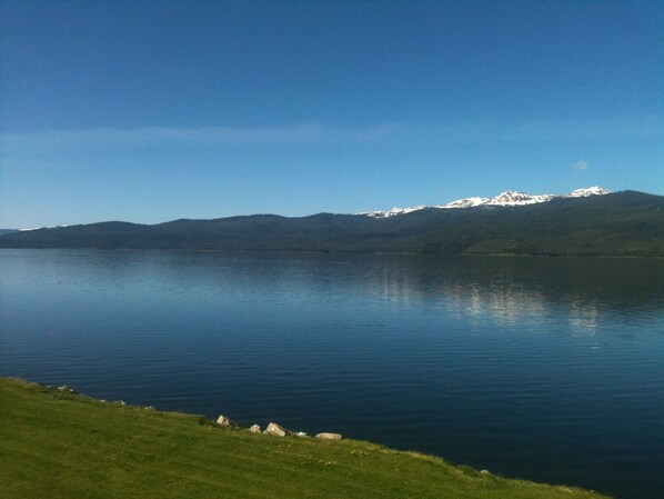 A calm lake with a mountain range in the background.