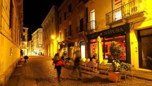 A cobblestone street at night with a café named 'Caffè Natura' on the right. - Appartamento al Duomo in the Historical center of the city (Vicenza)