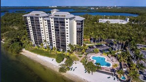 Un hotel de gran altura con múltiples balcones, un área de piscina y ubicación frente a la playa.
