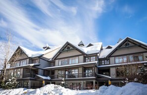 A multi-story hotel with a snow-covered roof, large windows, and balconies.