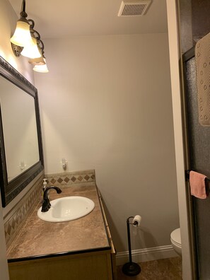 Een bad/douchecombinatie, handdoeken, toiletpapier