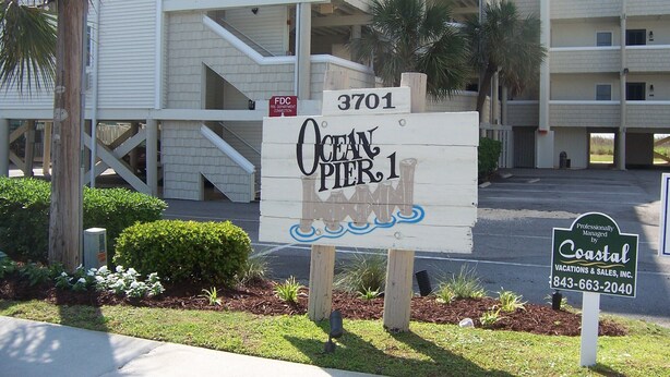 Letrero para Ocean Pier 1 con número de contacto de Coastal Vacations & Sales, Inc.