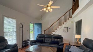 Un salon avec un canapé, une table basse et un escalier.