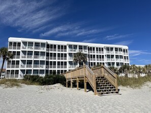 A multi-story hotel with balconies and a wooden staircase leading to the beach. - APRIL & MAY DISCOUNTED WKS !!NEWLY RENOVATED!! DIRECT OCEAN FRONT CONDO-Unit 104 (Myrtle Beach)