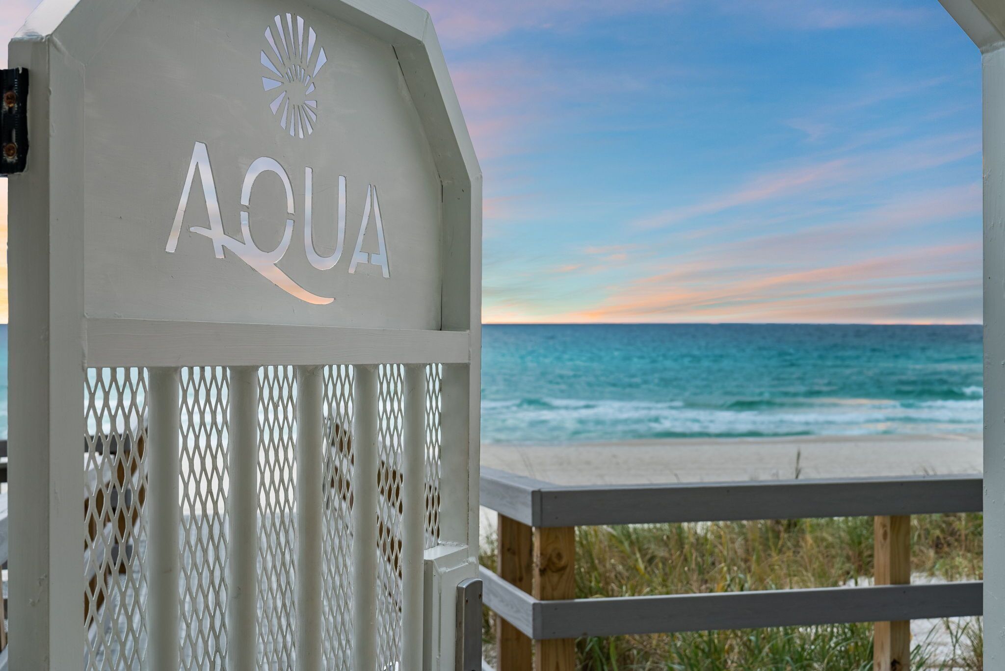 A beachside entrance with the name 'AQUA' and a view of the ocean.