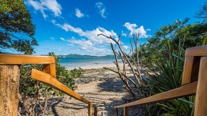 A wooden staircase leading to a beach with a clear view of the ocean and distant mountains. - Tamarindo's Hidden Gem, Tropical oasis 3 BR Beachfront Home, with private pool.
 (Tamarindo)