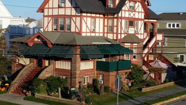 Ein zweistöckiges Haus im Tudor-Stil mit einem steilen Satteldach, Dachgauben und einer Ziegelauffassade.