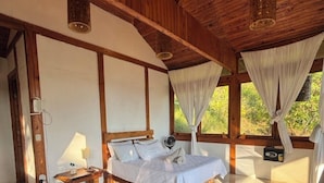Una habitación de madera con una cama, una mesita y una silla.