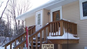Una escalera de madera que lleva a una casa con un letrero que dice 'Pine Place'.
