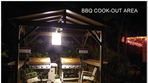Een barbecueplek met twee barbecues en stoelen.