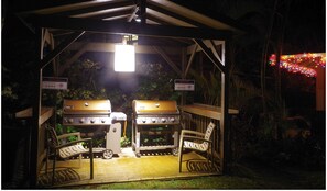 A BBQ cook-out area with two grills and chairs.