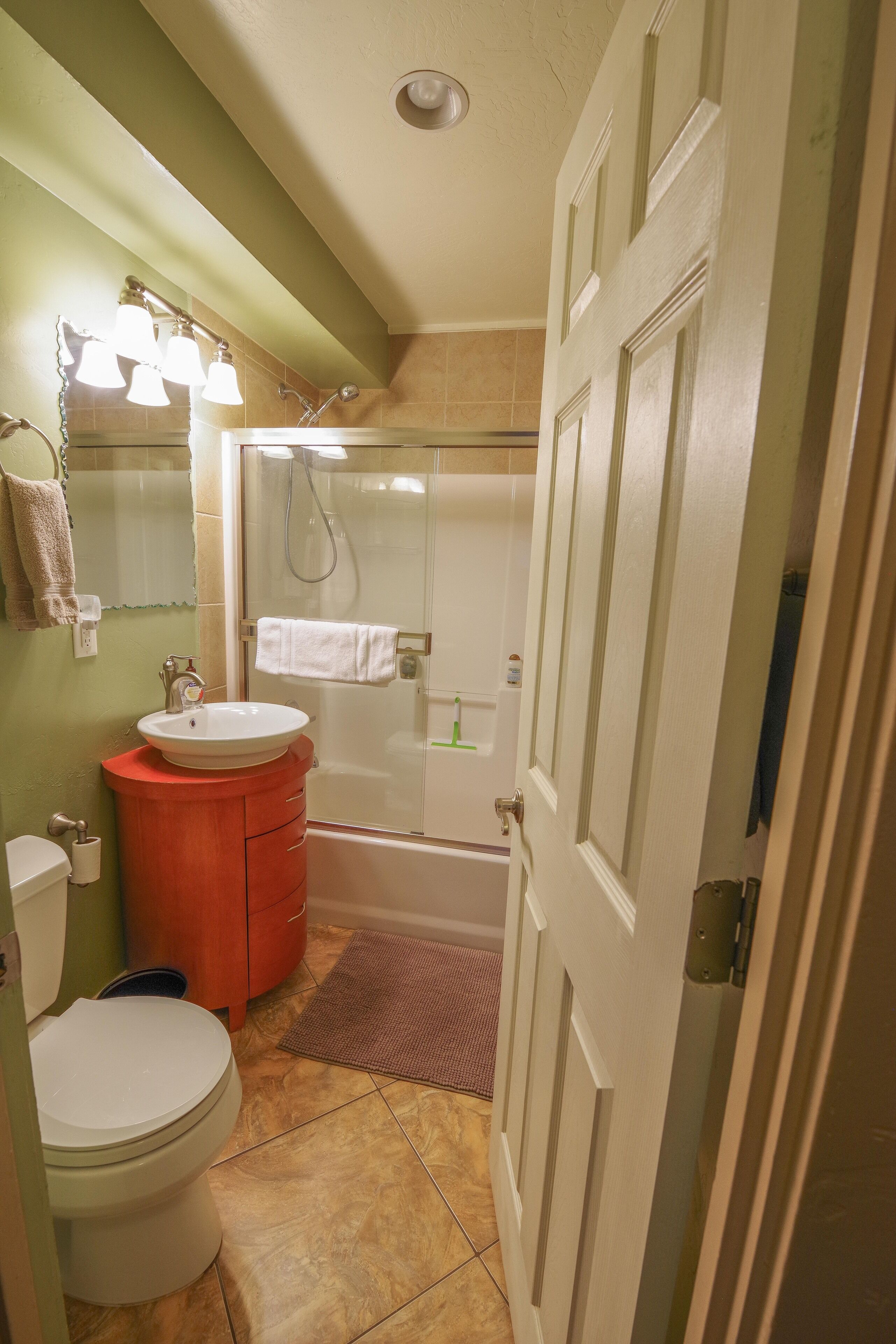 A bathroom with a sink, mirror, and toilet.