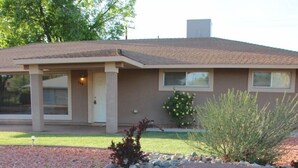 A house with a front yard featuring a rock garden and a small tree. - A Desert Bloom House (Page)