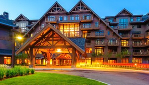 Un hôtel à plusieurs étages, doté d’une entrée imposante, caractérisée par un grand arc en bois.