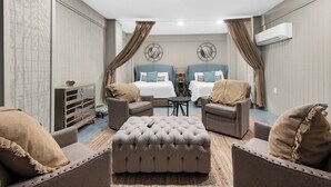 A hotel room with two beds, a sofa, a coffee table, and a decorative mirror. - ☀️ The Beach House | Designer 7BR w/ Huge Pool, Bunk Room + In-Law Suite (Pensacola Beach)