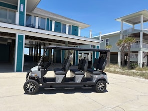 Un carrito de golf estacionado frente a un edificio con una entrada cubierta y un balcón.