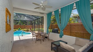 Une terrasse avec une piscine, du mobilier d’extérieur et un ventilateur de plafond.