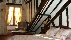 A bedroom with a bed, a chair, a table, and a lamp. - Luxury Affordable Vacation Home in Paris, Marais (Paris)