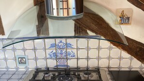 A kitchen with a gas stove, oven, and a stainless steel range hood. - Luxury Affordable Vacation Home in Paris, Marais (Paris)