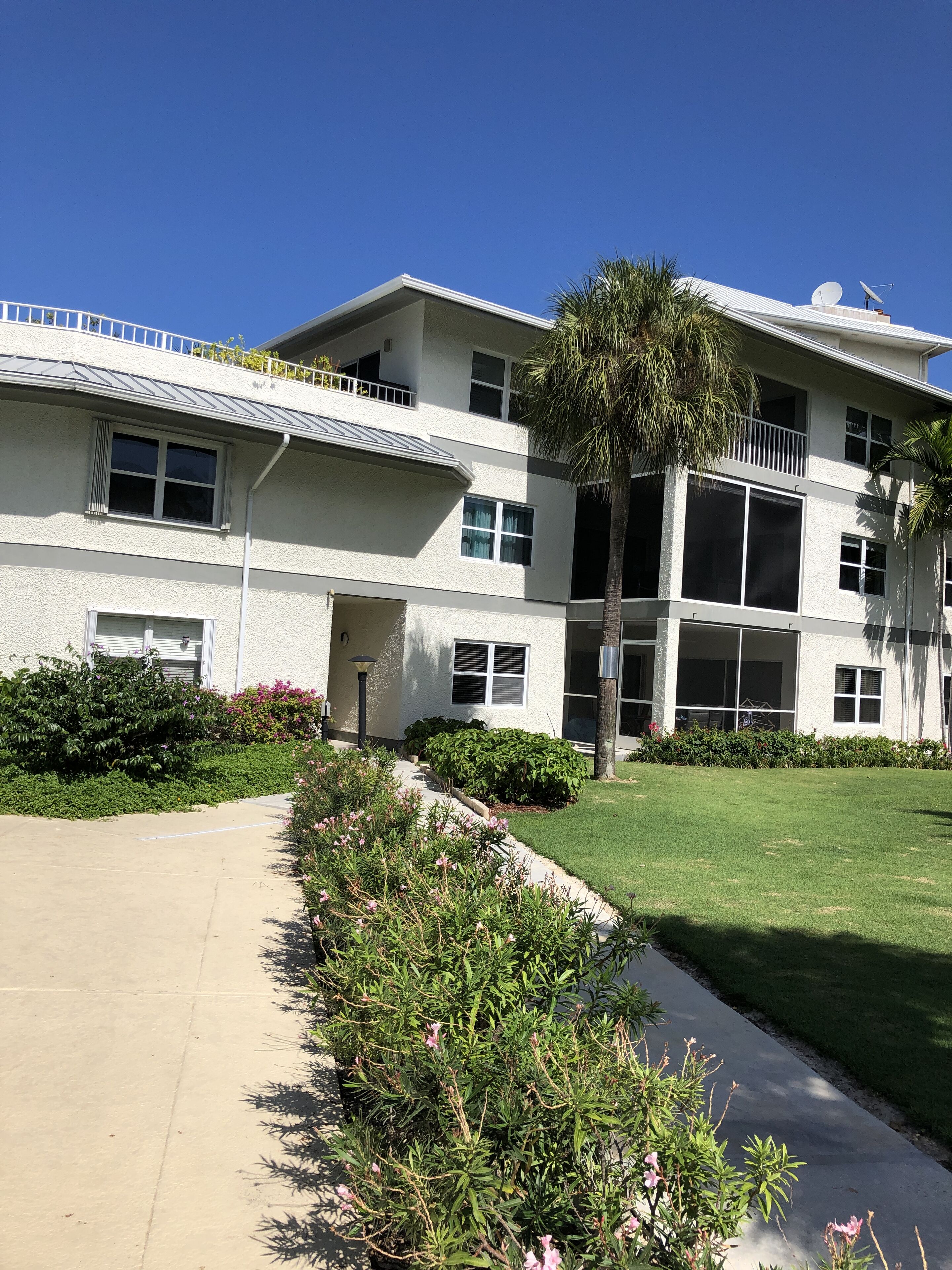 A multi-story building with a flat roof, large windows, and a satellite dish.