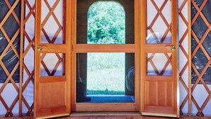 A wooden door with a glass window, set within a lattice structure. - Exquisite Accommodations Farmhouse with over 100 acres (Castleton)