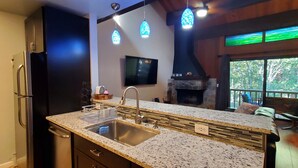 Una cucina moderna con piani in granito, elettrodomestici in acciaio inossidabile e un camino in pietra.
