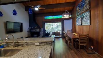 A modern kitchen with granite countertops, a built-in stove, and a dining area with wooden chairs and a table.