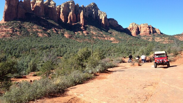 A rugged landscape with a dirt road, rocky formations, and sparse vegetation. - Relaxing, Spiritual, Meditative Residential House - Large yard!  MONTHLY RENTAL. (Sedona)