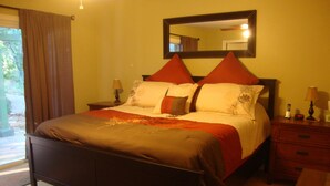 A neatly made bed with a headboard, two bedside tables with lamps, and a large mirror above the bed. - Relaxing, Spiritual, Meditative Residential House - Large yard!  MONTHLY RENTAL. (Sedona)