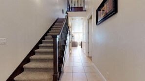 A staircase with carpeted steps and a handrail, leading to an upper floor.