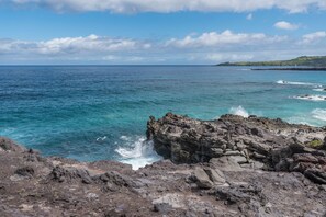 A rocky coastline with clear blue sea and distant land. - Kapalua Bay Villa 33B3  Oceanfront Views (Lahaina)