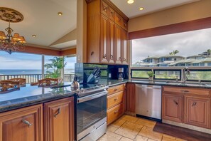 A modern kitchen with wooden cabinets, stainless steel appliances, and a large island.