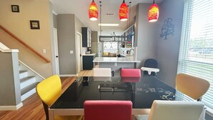 A dining area with a black table, yellow and red chairs, and pendant lights. - 4BR/4BA Quiet Central Frisco Home - Near Star Center, UNT, Toyota Sta. + Hot Tub (Frisco)