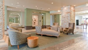 Una hall con una colonna in pietra, divani decorati e un tavolino in legno.