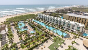 Un resort con diverse piscine, una spiaggia e vista sull'oceano.