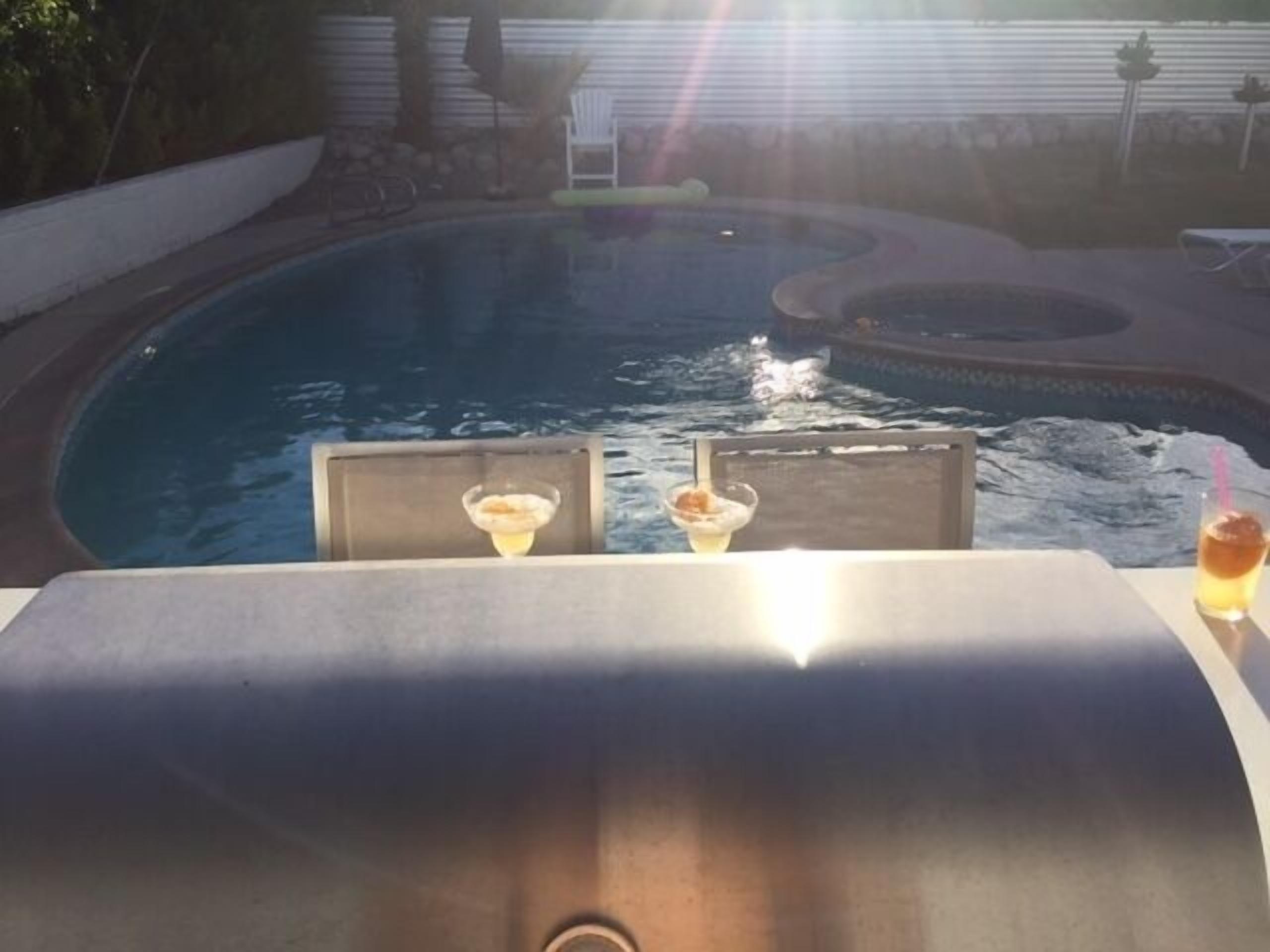Eine Poolbar mit zwei Getränken und einem Grill.