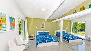 A modern bedroom with a large bed, a seating area, and a large mirror reflecting the room. - Beautiful! Remodeled Mid-Century Alexander w/ SALTWATER pool, spa, bikes, & more (Palm Springs)