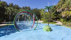 Un espace de jeux aquatiques comprenant plusieurs anneaux colorés et une fontaine en forme de tortue.
