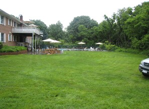 A grassy backyard with a pool, picnic tables, and umbrellas. - NOFO  ESCAPE relax-swim-enjoy. Bachelorettes-Weddings-Family vacation (Greenport)