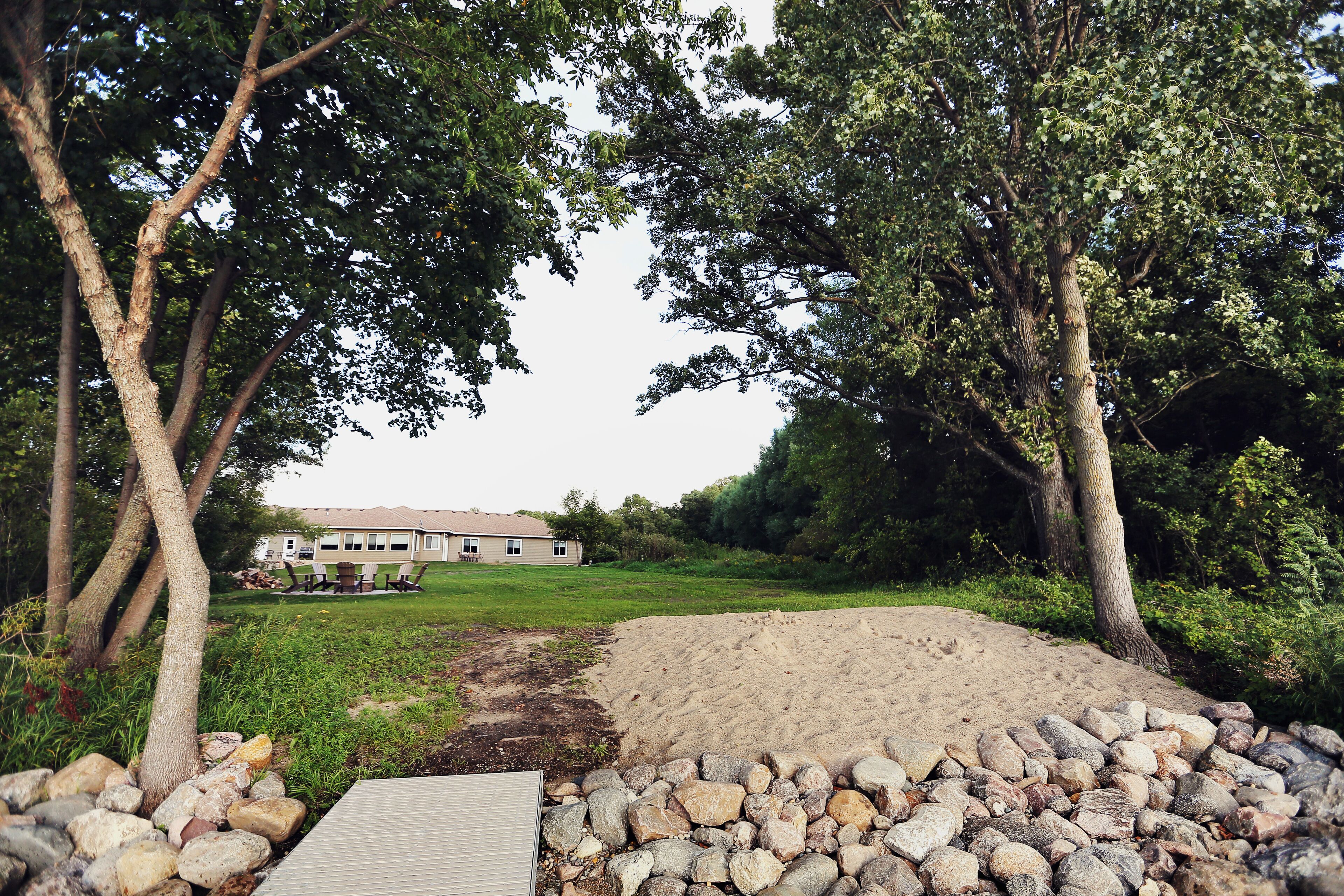 A house with a paved driveway and a stone wall.