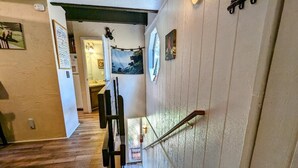 Una escalera de madera con barandilla que lleva a un piso superior.
