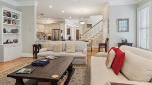 A spacious living room with a sofa, coffee table, and a kitchen in the background. - Tons of Space & Gorgeous Porch! (Savannah)