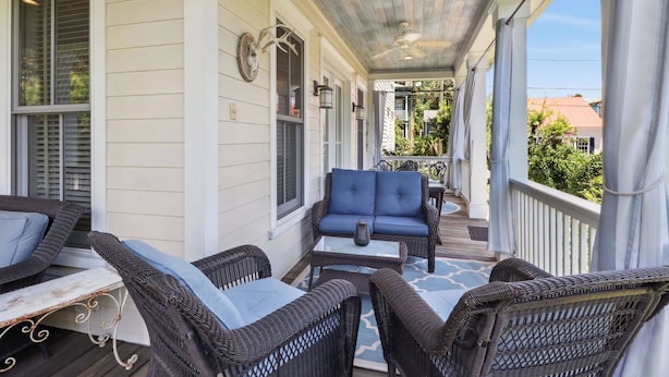 A covered porch with wicker furniture, a ceiling fan, and a decorative wall plate. - Tons of Space & Gorgeous Porch! (Savannah)