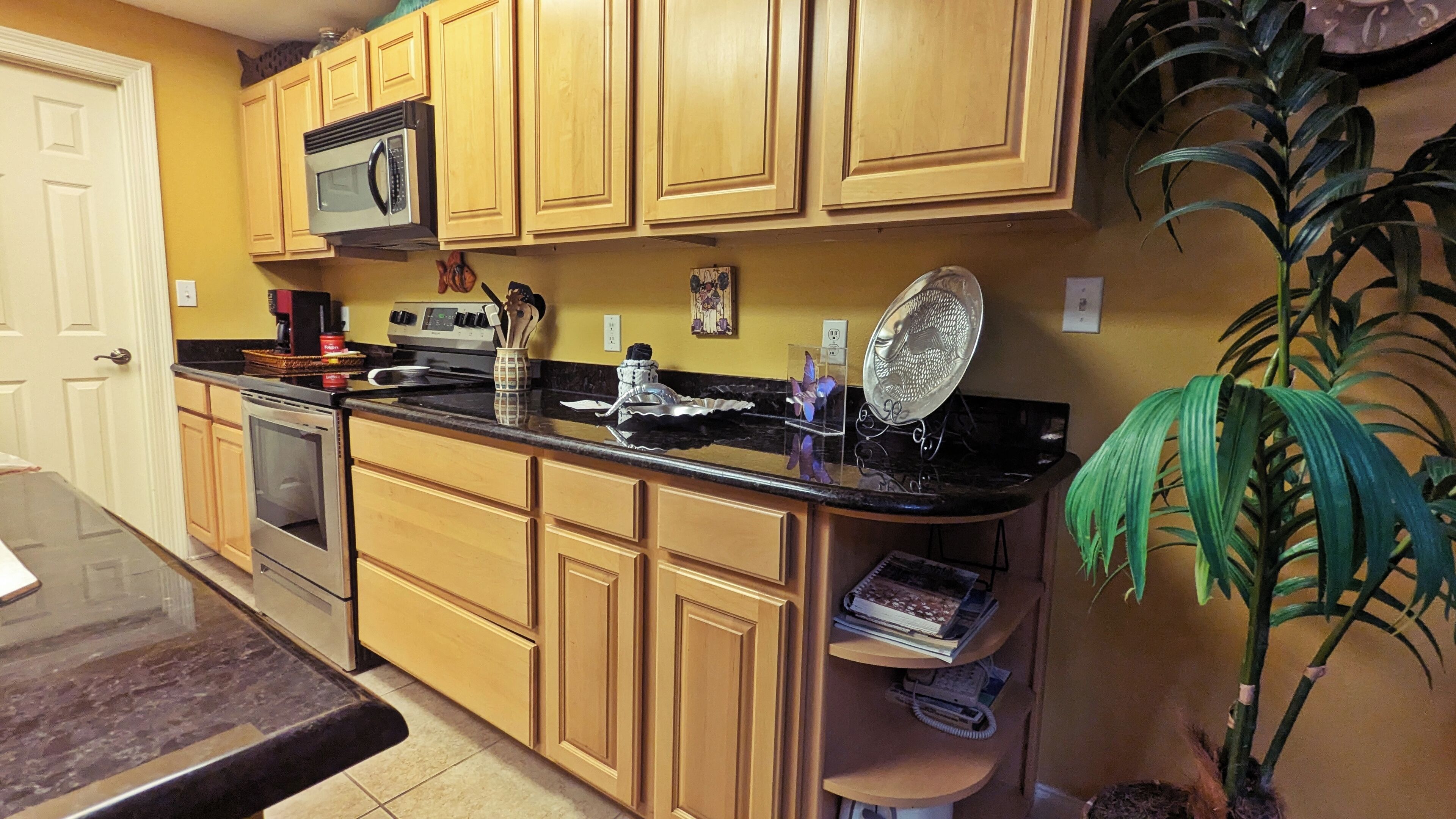 A kitchen with wooden cabinets, a microwave, a stove, and a sink.
