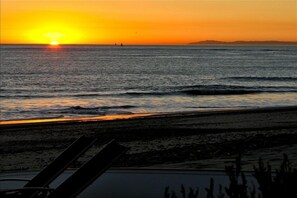 A sunset over the ocean with a beach in the foreground. - LARGE CONTEMPORARY HOME ON THE SAND, HOT TUB, CHEF’S KITCHEN, ENDLESS VIEWS (Capistrano Beach)