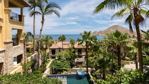 A resort with a pool, palm trees, and a view of the ocean. - 3rd Night Free-Luxury Oceanview HBC Resort Residence-Medano Beach (Cabo San Lucas)